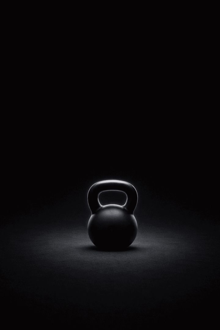 Glowing kettlebell in darkness gym wallpaper